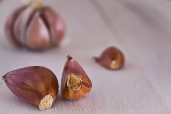 Beyaz masada bir sürü mor sarımsak var.
