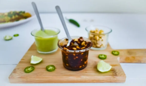 Sebze doğrama tahtasında fıstık ve salsa macha ve yeşil sos.