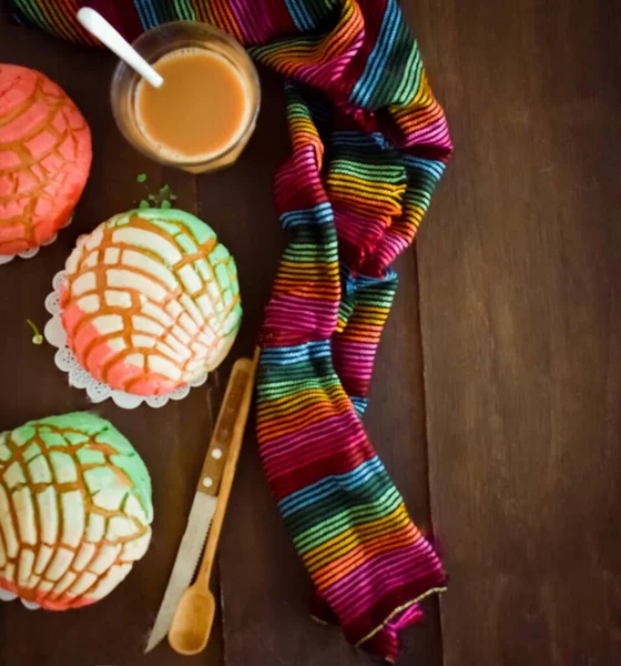 Süt rengi şallı kahve, tahta kürek ve tahta bıçaklı renkli tatlı ekmek.