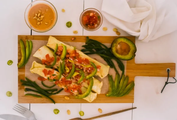 Sebze doğrama tahtasına ıspanaklı ve fıstık soslu patates flütü.