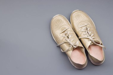 Gri bir arka planda altın renkli açık renkli çizmeler.