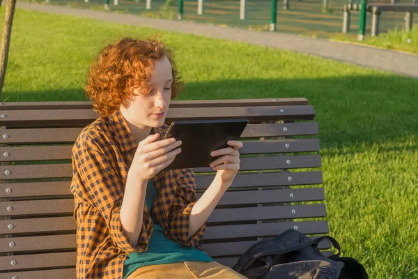 Adolescente 12-14 com um gadget ao ar livre — Fotografia de Stock