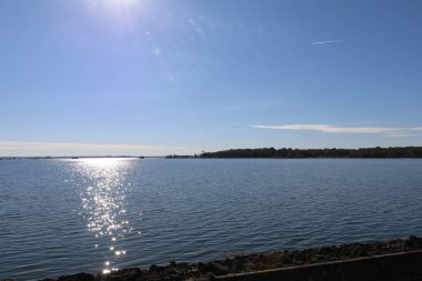Sakin mavi göl güneş ışığını yansıtıyor. Fransa, Champagne, Lac du Der 'de açık bir günde.