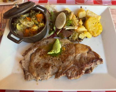 Hakiki ızgara et tabağı, kızarmış patates, karışık sebze ve taze salata.