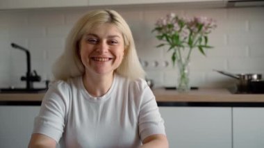 Kameraya bakıp evde gülümseyen mutlu beyaz bir kızın portresi. Genç, mutlu müşteri müşteri başarılı iş kadını konsepti