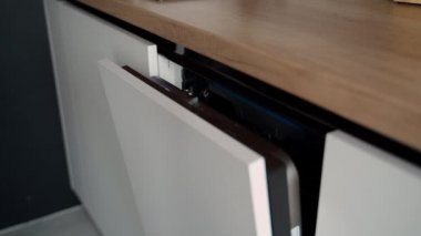 Müşteri bir bulaşıkçı seçiyor. Beyaz bulaşık makinesinin kapısını açıyorum.