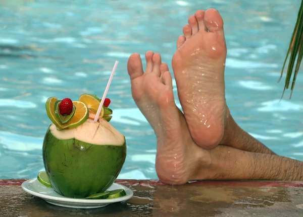 Kokosnoot cocktail aan de rand van het zwembad Stockfoto
