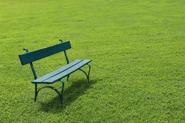 Eenzaam bankje op korte gemaaid gras — Stockfoto