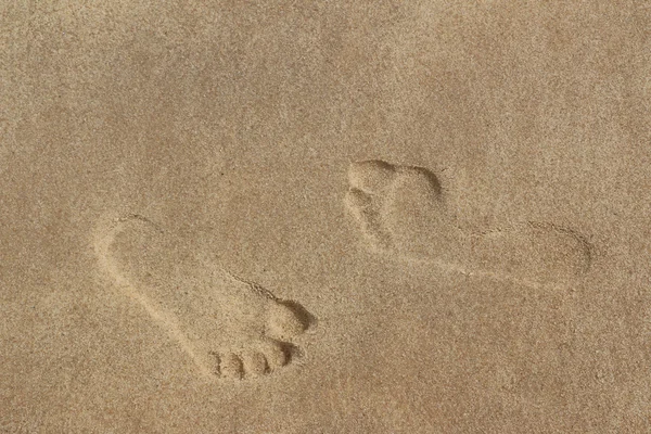 Twee voetafdrukken op zand Stockafbeelding