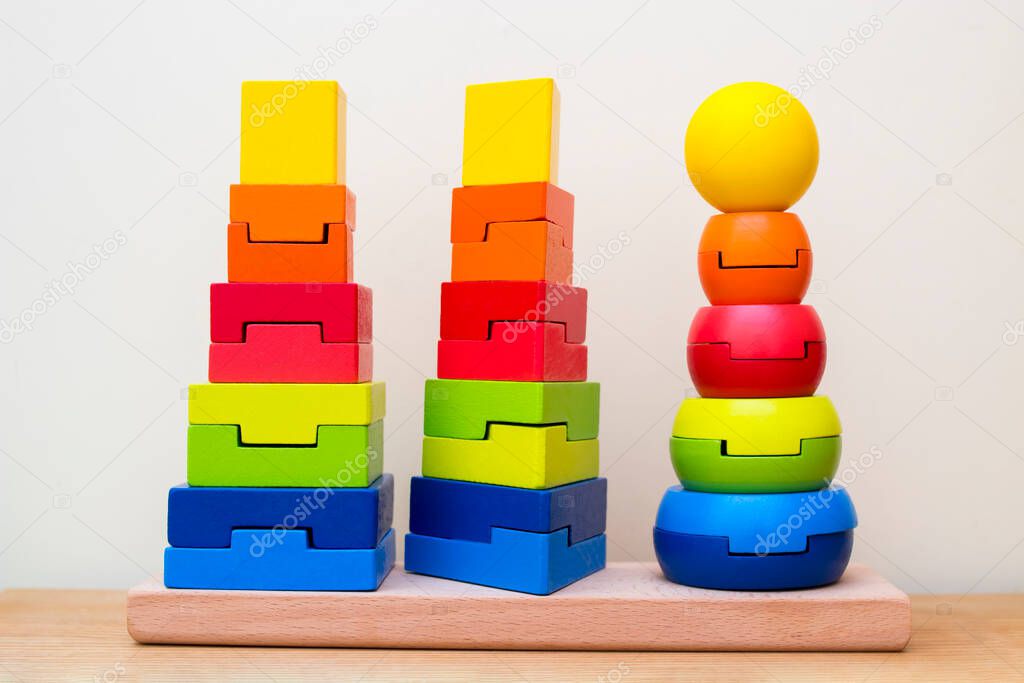 Three colored toy towers, on each tower the figures are distributed strictly according to their shapes.
