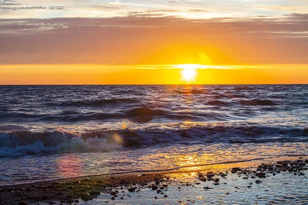 Heller Sonnenuntergang an der Ostseeküste, Wellen, Steine und Sand — Stockfoto