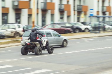Şehir rotasında dörtlü bisiklet bir arabayı sollar.