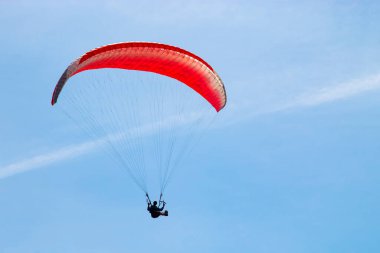 Paraşüt paraşütü açık mavi gökyüzünün arka planında uçuyor