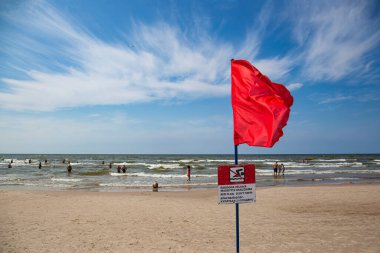 yüzmek yasaklandığında ve kırmızı bayrak sallandığında sahilde yüzen yaramaz tatilciler