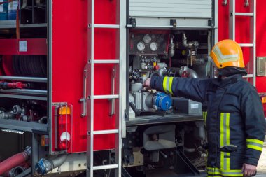 İtfaiyeciler kırmızı itfaiye aracında itfaiye arabasıyla iş başında.