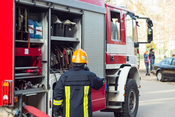 İtfaiyeciler kırmızı itfaiye aracıyla iş başında.