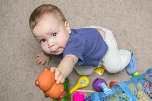 Любопытный ребенок, изучающий игрушки — стоковое фото
