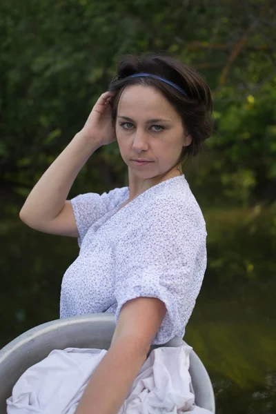 Крестьянка стирает одежду в реке — стоковое фото
