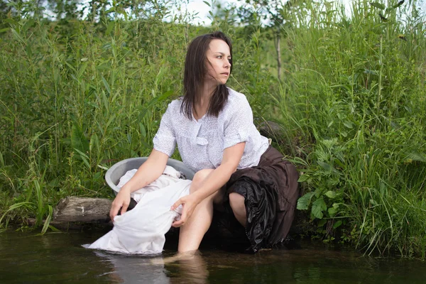 Donna contadina lava i vestiti nel fiume — Foto Stock
