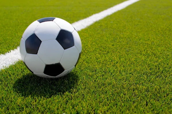 Pelota de fútbol en el campo verde — Foto de Stock