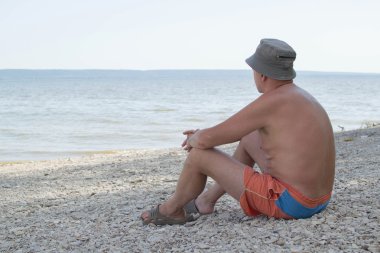 adam nehir kıyısında oturur