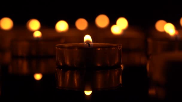 Свечи горят на черном фоне — стоковое видео