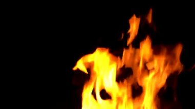 Alevler siyah arka planda yanıp sönüyor.