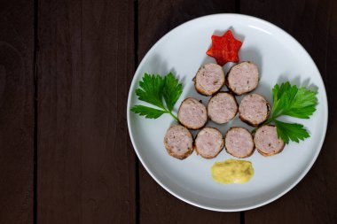 Noel ağacı şeklinde bir tabakta ızgara sosis. 