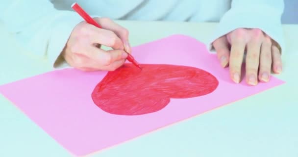 Vrouwelijke hand tekent een rood hart op papier. Liefdessymbool. Valentijnsdag — Stockvideo
