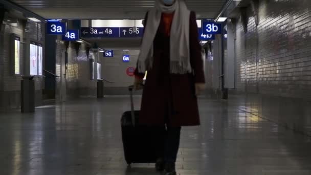 여행 가방을 든 소녀가 빈 기차역을 걸어 다닌다 — 비디오