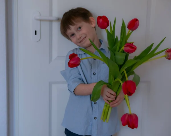 Fiú egy nagy csokor tulipánnal. Nők napja. Anyák napja.. — Stock Fotó