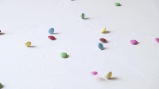 Яркие цветные конфеты падают на белом фоне. — стоковое видео