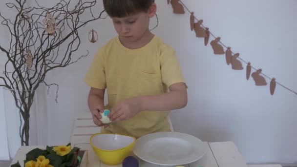 Szczęśliwej Wielkanocy. Mały chłopiec obiera wielkanocne jajko — Wideo stockowe