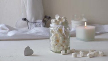 Beyaz bir masada, bardakta şekerlemeler.