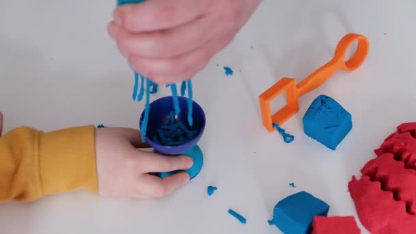 Bir çocuğun ve bir yetişkinin elleri kinetik kumla oynuyor.. — Stok video