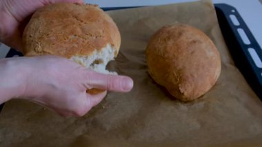 Kadın elleri taze ekmek kırıyor.