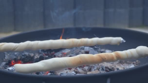 Grilling a bread on a stick over a campfire — Stock Video