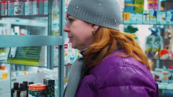Das Mädchen in der Apotheke, um Medikamente und Pillen zu kaufen — Stockvideo
