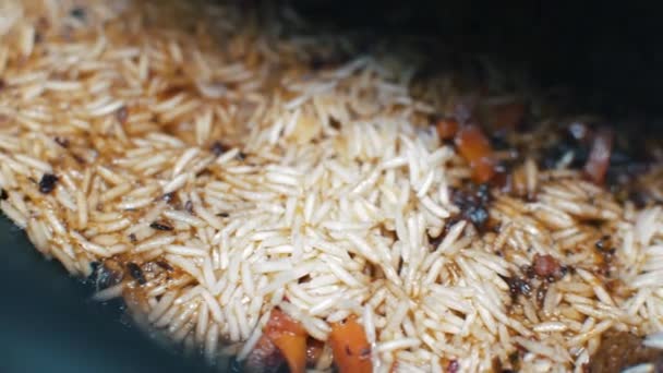 Подготовка Pilaf в котле, рис, мясо, специи — стоковое видео