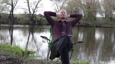 İşadamı oturan ile bir Tablet ve iş için kamp için nehir tarafından zorlanır