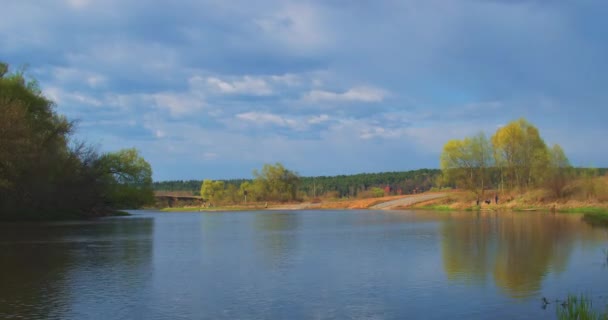 Timelapse : Flux fluviaux au début du printemps. les Nuages Hauts au-dessus. Pêcheurs pêchent le poisson, les gens viennent pour pique-niquer — Video