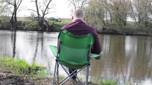 Zakenman zitten door de terug met een Tablet en is gedwongen om het werk voor de Camping aan de rivier — Stockvideo