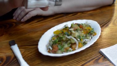 Genç kadın Sprinkles tuz sebze salatası