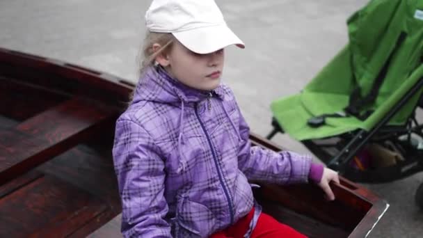 Dziewczyna siedzi w drewnianych łodzi — Wideo stockowe