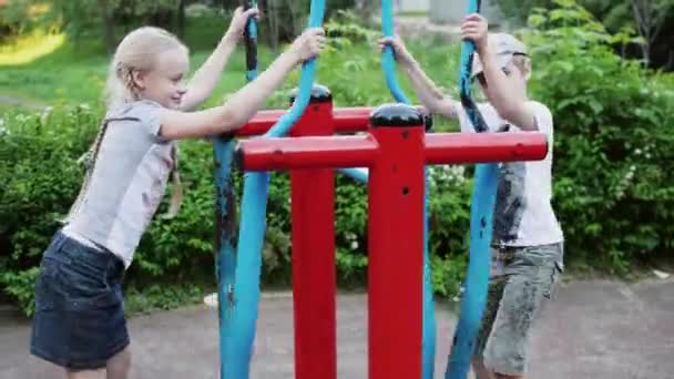 Chłopiec i dziewczynka na placu zabaw — Wideo stockowe