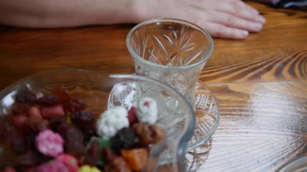 Чай наливают в чашку чая из стекла в прозрачное стекло — стоковое видео