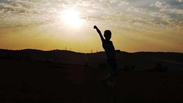 A silhueta de um menino em um fundo do sol Dança Dança engraçada — Vídeo de Stock