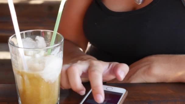 Das Mädchen im Café spielt ein Telefon, das auf dem Tisch liegt — Stockvideo