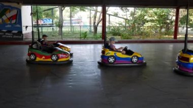 Çocuk eğlence parkında elektrikli araçlara binmek.