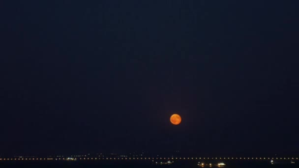 Timelapse la luna sale del horizonte sobre las luces de la ciudad — Vídeos de Stock